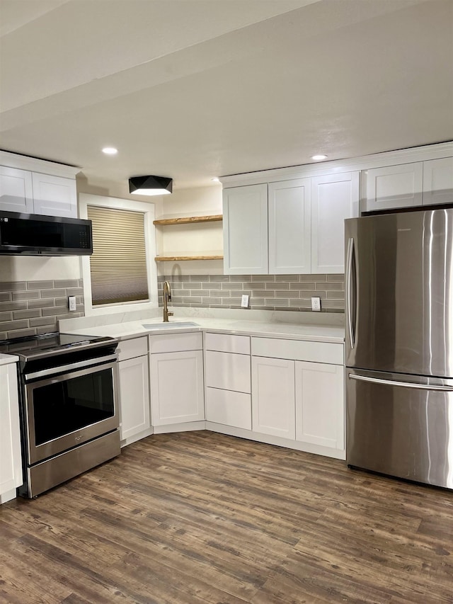 kitchen featuring sink, tasteful backsplash, appliances with stainless steel finishes, dark hardwood / wood-style flooring, and white cabinets