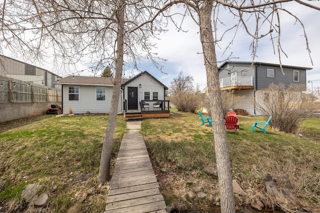 back of property with a wooden deck and a yard