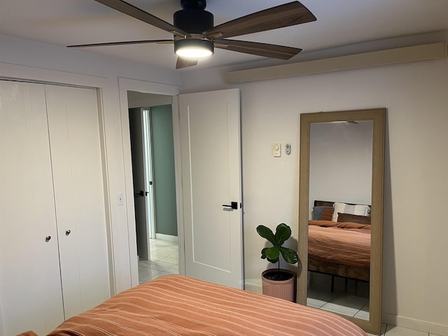 tiled bedroom with ceiling fan and a closet