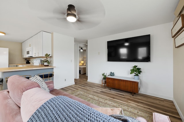 living room featuring ceiling fan and light hardwood / wood-style flooring