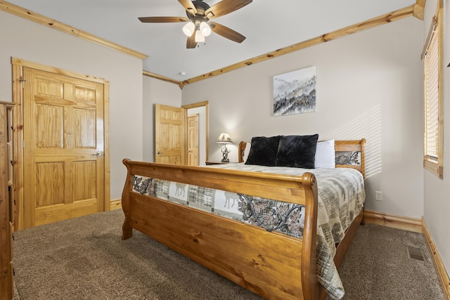 carpeted bedroom featuring baseboards, ornamental molding, and a ceiling fan