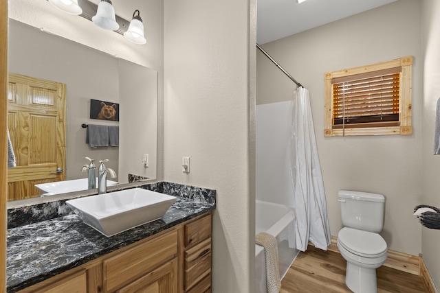 full bathroom with vanity, toilet, hardwood / wood-style floors, and shower / bath combo