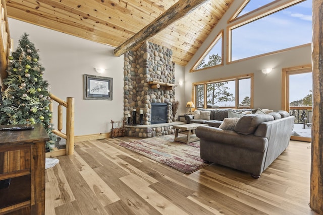 living area featuring high vaulted ceiling, a stone fireplace, wooden ceiling, stairway, and hardwood / wood-style floors