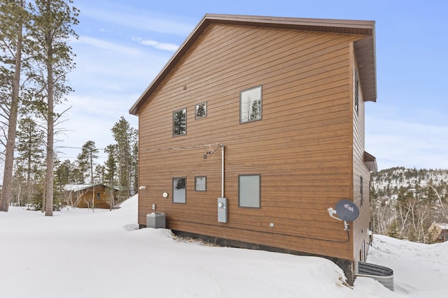 snow covered back of property with central AC unit