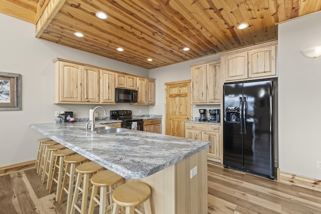 kitchen featuring wood ceiling, a peninsula, black appliances, light brown cabinets, and a sink