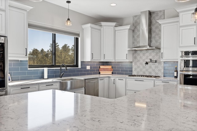7102 Marvel Mountain Rdg, Rapid City, SD 57702 - kitchen with appliances with stainless steel finishes, pendant lighting, white cabinets, light stone countertops, and wall chimney exhaust hood