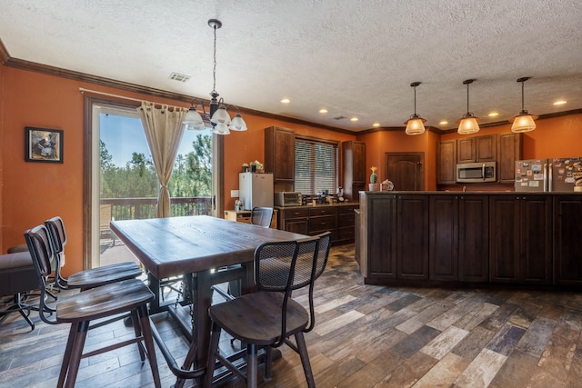 dining space with crown molding, dark wood-type flooring, and a textured ceiling