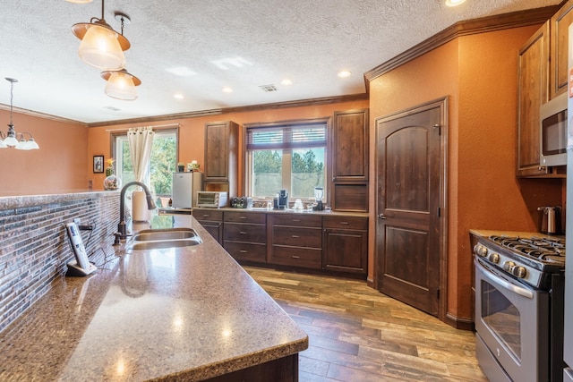 kitchen with appliances with stainless steel finishes, decorative light fixtures, sink, dark hardwood / wood-style flooring, and ornamental molding