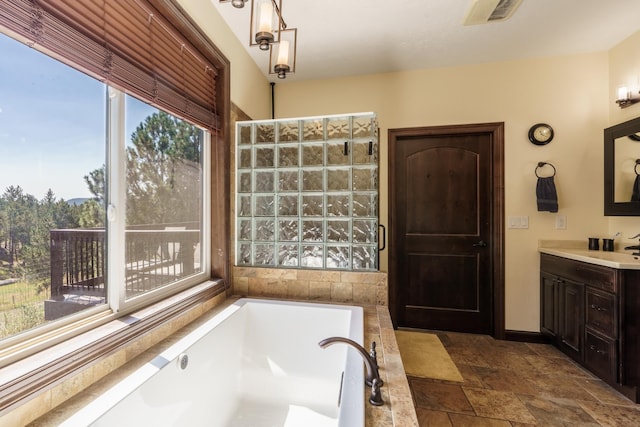 bathroom with vanity and tiled bath