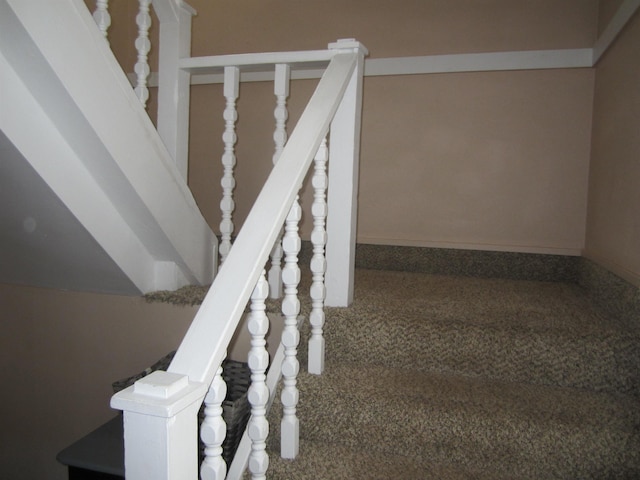 staircase featuring carpet