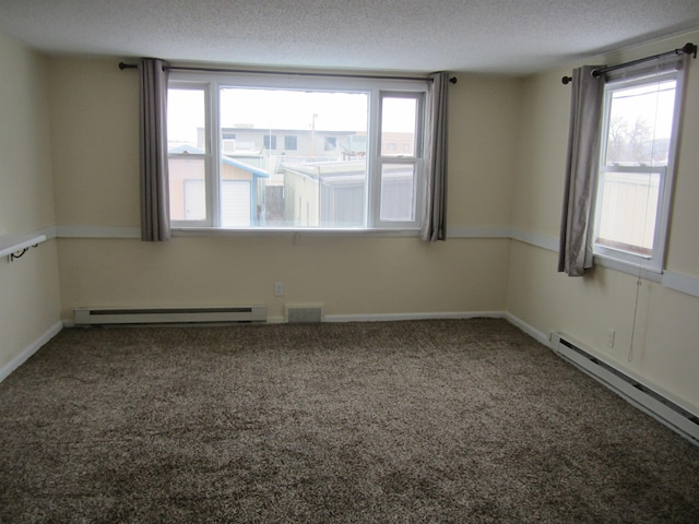 empty room with plenty of natural light, a baseboard radiator, a textured ceiling, and carpet flooring