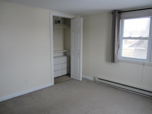 unfurnished bedroom with light colored carpet, baseboard heating, and a closet