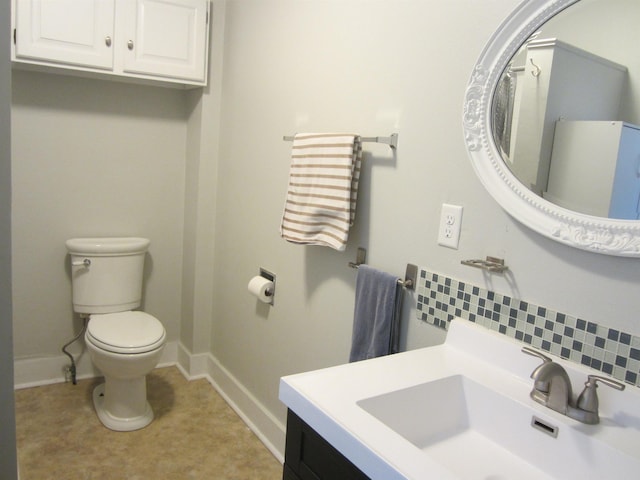 bathroom with vanity, toilet, and decorative backsplash