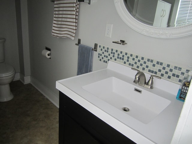 bathroom featuring tasteful backsplash, vanity, and toilet