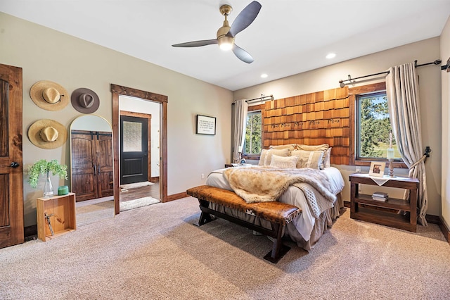 carpeted bedroom featuring multiple windows and ceiling fan