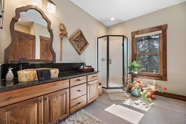 bathroom with an enclosed shower, vanity, and hardwood / wood-style flooring