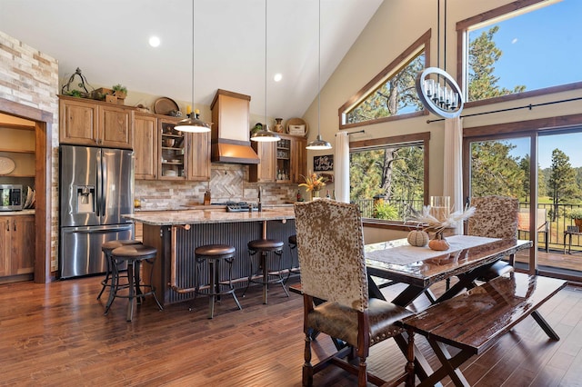 dining area featuring dark wood-type flooring and high vaulted ceiling