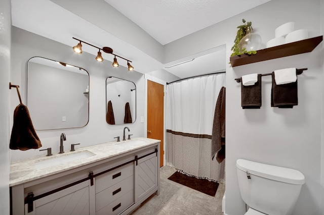 bathroom featuring vanity, a textured ceiling, and toilet