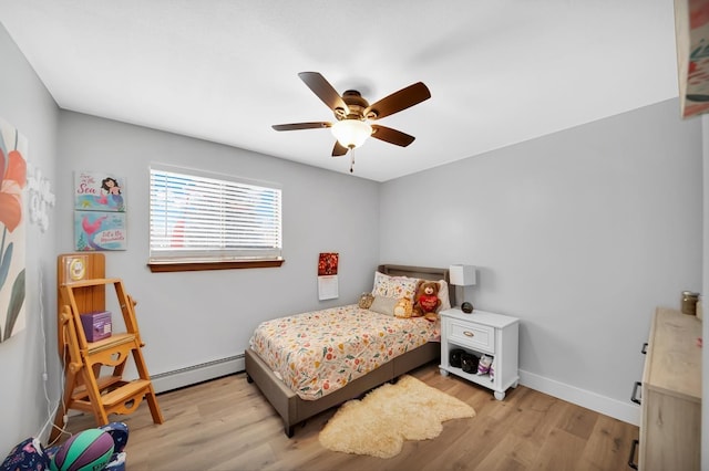 bedroom featuring ceiling fan, baseboard heating, and light hardwood / wood-style floors