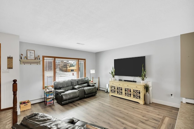 living room featuring hardwood / wood-style flooring, a textured ceiling, and baseboard heating