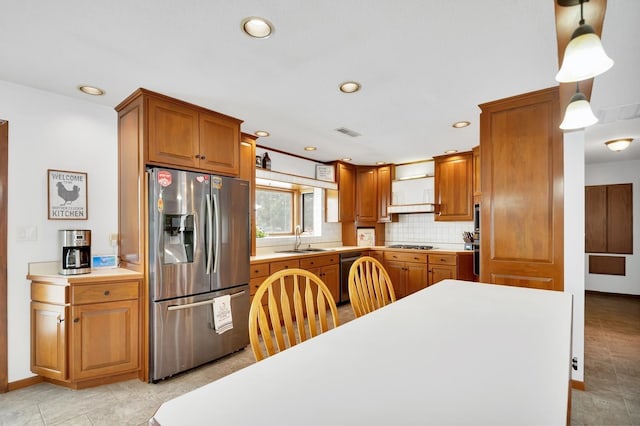 kitchen featuring sink, tasteful backsplash, decorative light fixtures, light tile patterned floors, and appliances with stainless steel finishes