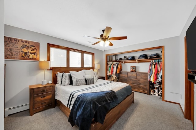 carpeted bedroom featuring a baseboard radiator, ceiling fan, and a closet