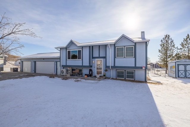 bi-level home featuring a garage and central AC unit