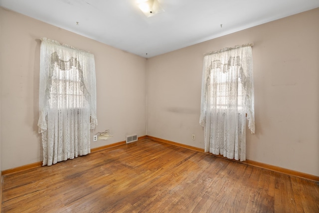 spare room featuring hardwood / wood-style flooring and a wealth of natural light