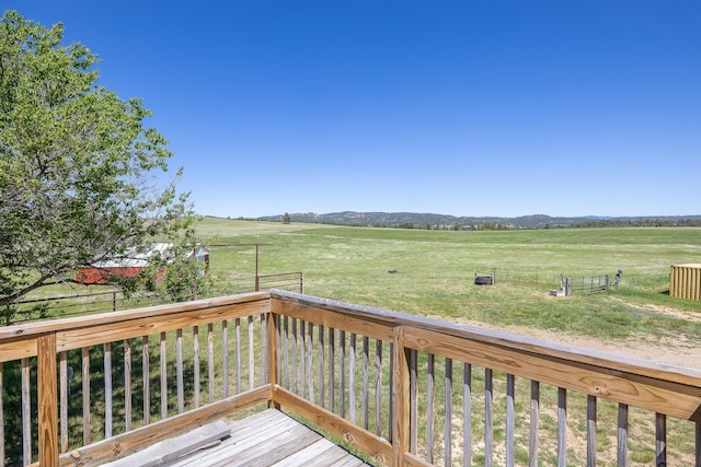 deck featuring a rural view and a lawn