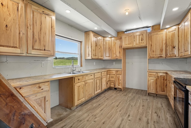 kitchen with black electric range oven, light brown cabinets, sink, and light wood-type flooring