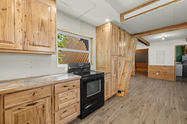 kitchen with washer / dryer, black electric range, light brown cabinets, beamed ceiling, and light hardwood / wood-style floors