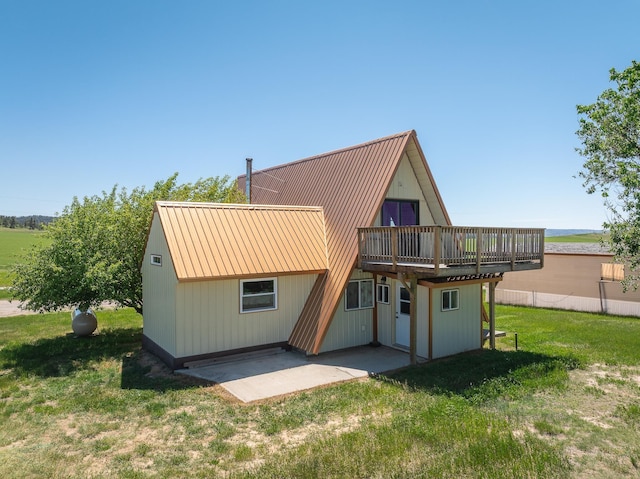 rear view of property featuring a yard, a patio, and a deck