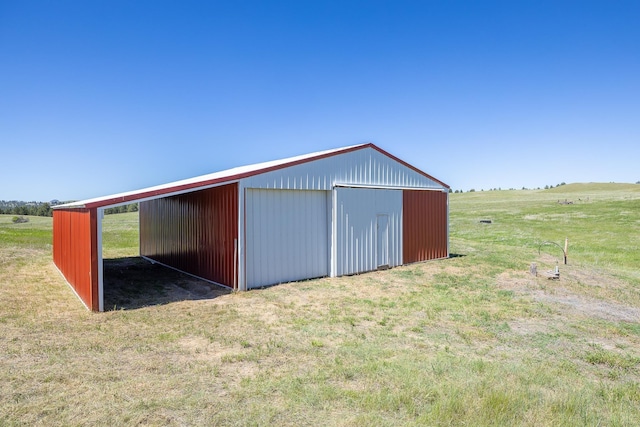 view of outdoor structure featuring a yard and a rural view