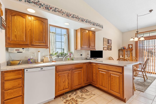 kitchen with vaulted ceiling, pendant lighting, dishwasher, sink, and kitchen peninsula