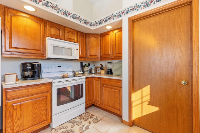 kitchen featuring light tile patterned floors and white appliances