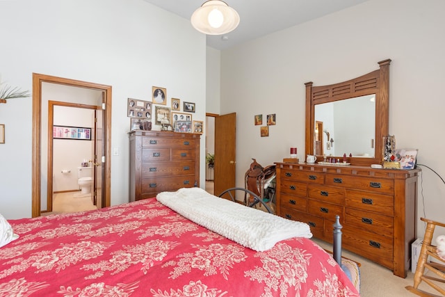 bedroom featuring light colored carpet and ensuite bathroom