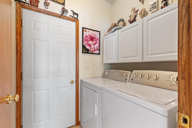 laundry area with washing machine and dryer and cabinets