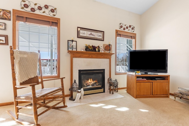 sitting room featuring light colored carpet, a healthy amount of sunlight, and a tiled fireplace