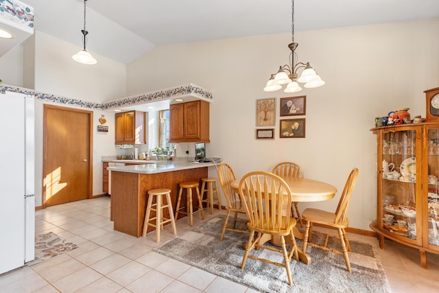 tiled dining room featuring a chandelier and vaulted ceiling