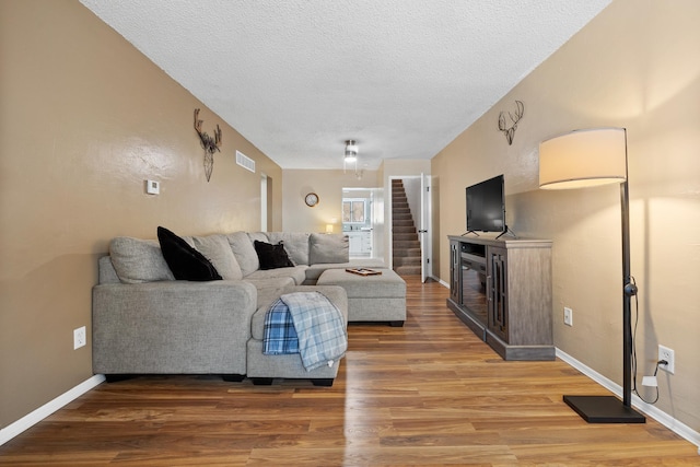 living room with wood-type flooring and a textured ceiling