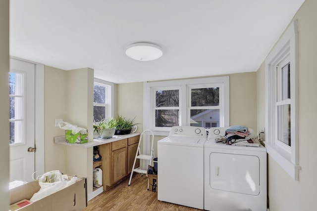 laundry area with separate washer and dryer and light wood-type flooring