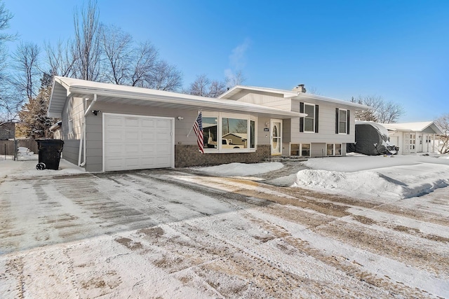 split level home with a garage and brick siding