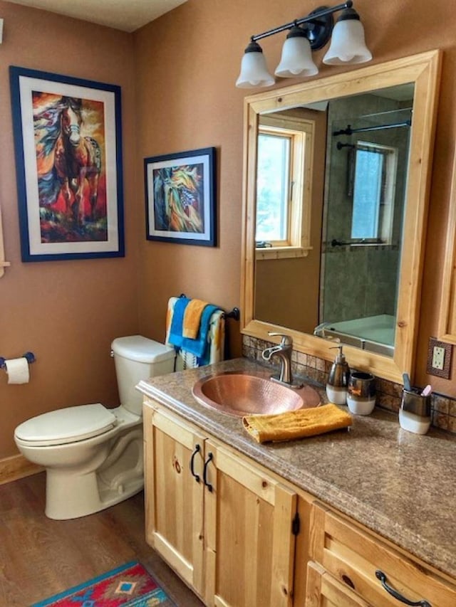 full bath featuring vanity, wood finished floors, and toilet