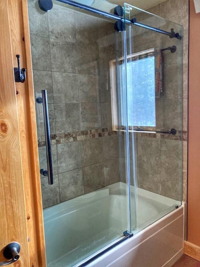 bathroom with shower / bath combination with glass door