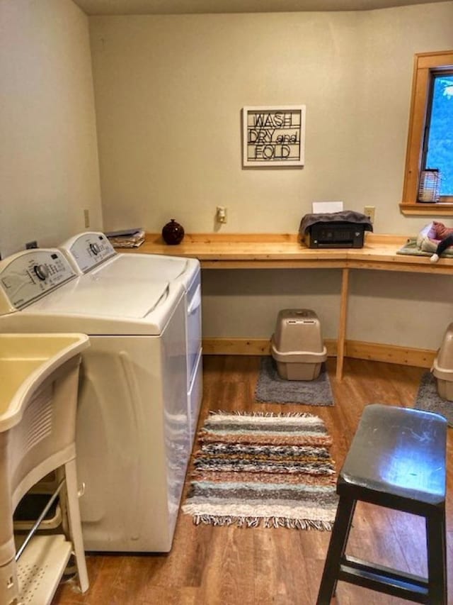 laundry area featuring laundry area, baseboards, washer and clothes dryer, and wood finished floors