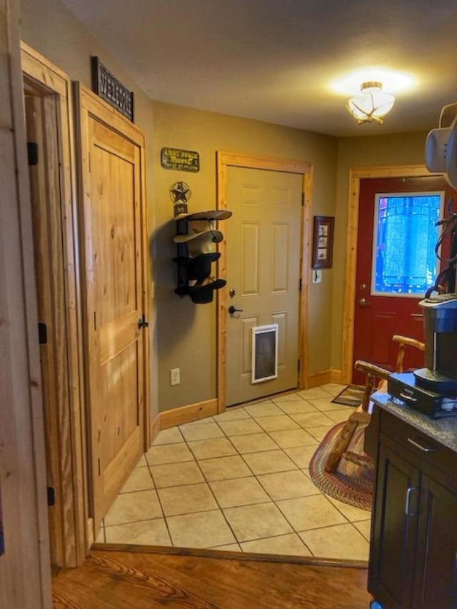 entryway featuring light tile patterned flooring and baseboards