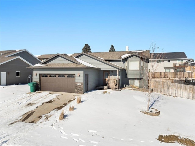 view of front of property featuring an attached garage and fence