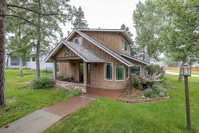 view of front of property featuring a front lawn, board and batten siding, and a shingled roof