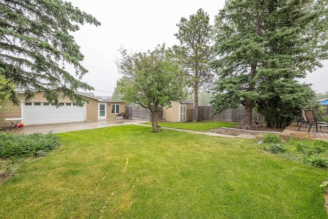 view of yard with a fenced backyard, a storage unit, and an outbuilding