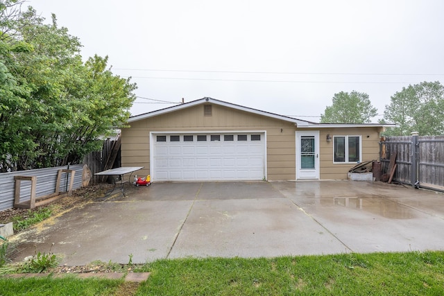 exterior space featuring a detached garage and fence